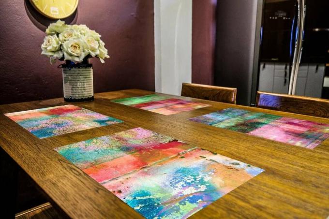 Künstlerisch farbige Tischsets in leuchtendem Regenbogen